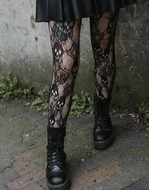 Net tights with skulls and roses pattern, worn with skirt and boots